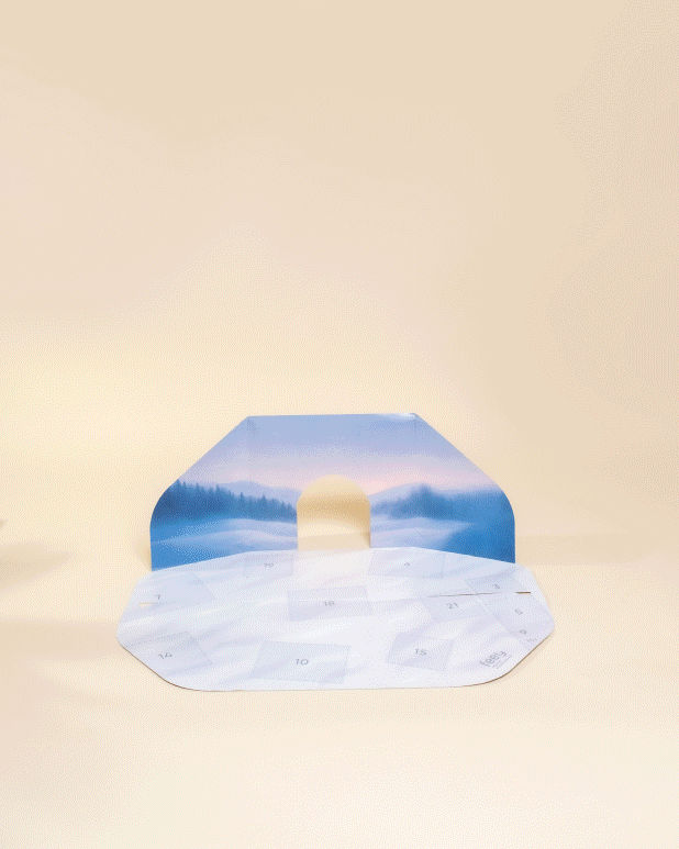 Die Hände öffnen die Türen des minimalistischen Pflanzen-Adventskalenders, der wie ein Iglu geformt ist, und geben den Blick frei auf kleine Pflegeprodukte in jedem Fach. Der hellbeige Hintergrund unterstreicht sein klares, modernes Design.